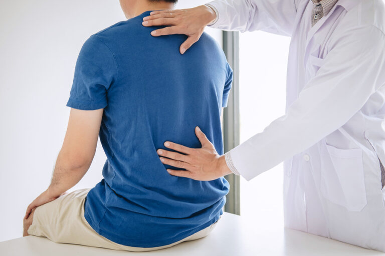 Picture of doctor checking patient's back