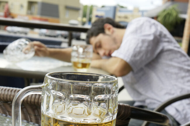 Drunk young man holding empty pitcher