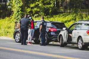 car accident scene with police, driver needs to call their Houston car accident attorney